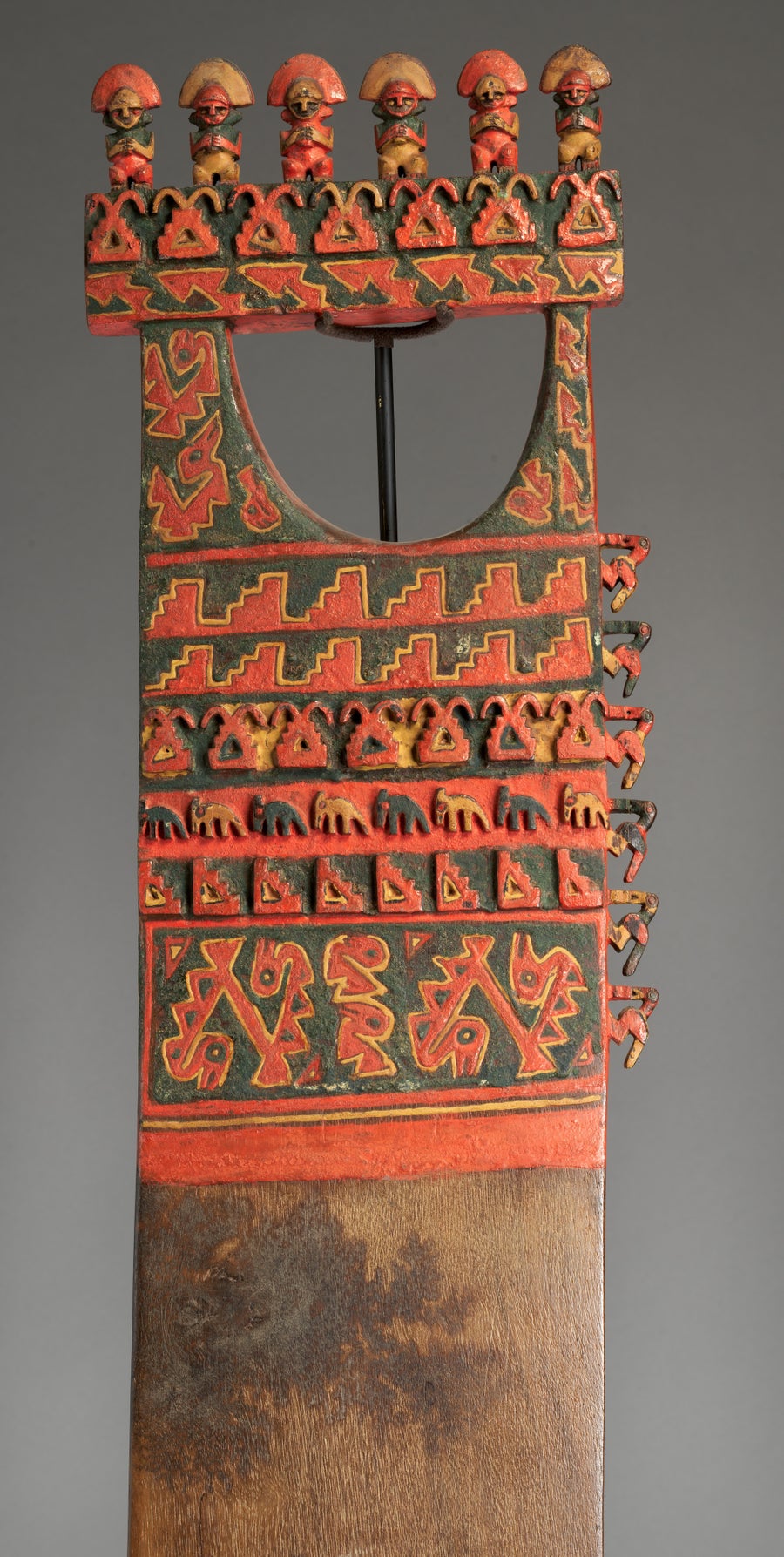 مقبض مزخرف فوق شفرة على شكل مجرفة منقوشة باللونين الأحمر والأسود تصور طيورًا بحرية وأشكالًا موجية.