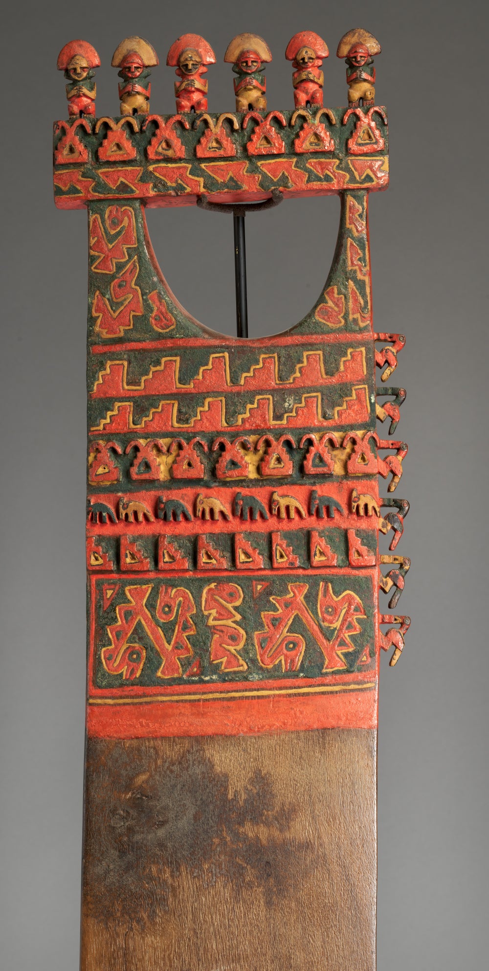 A decorative handle atop a shovel-like blade patterned in red and black depicting seabirds and wave motifs.