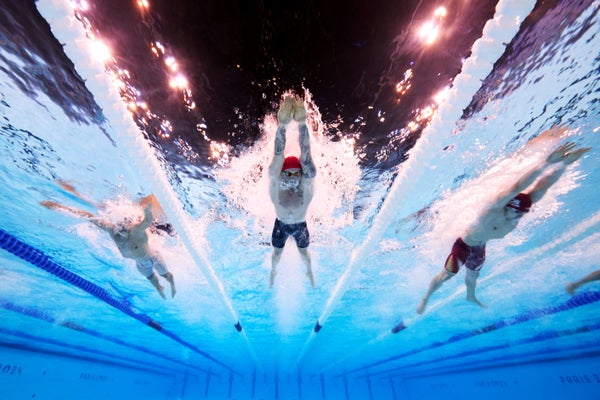 Underwater view of three swimmers competing in lanes