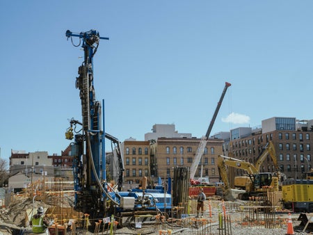 A drill rig operates at the muddy Brooklyn waterfront site of The Riverie in early 2023.