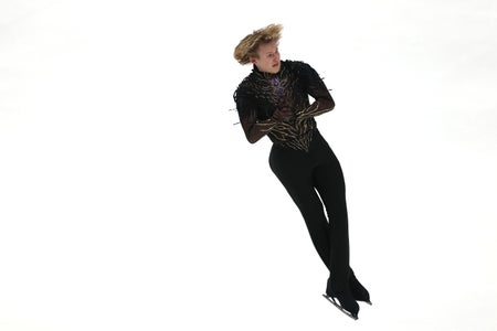 A male figure skater jumping mid-air