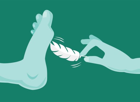 A hand is delicately holding a feather and tickling the bottom of a foot.