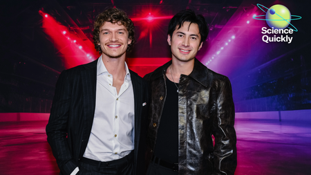 An image of Heated Rivalry actors Connor Storrie and Hudson Williams smiling and standing side by side.