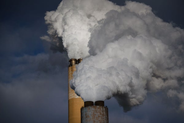 Dirty smoke coming out of two smokestacks on coal fired plant.