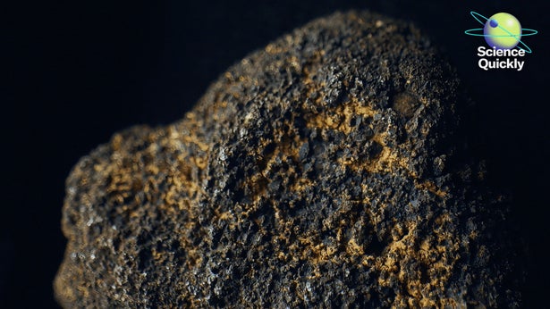 A close up image of a rock with a rough surface with orange coloration