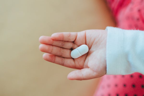 White pill on hand of a child.