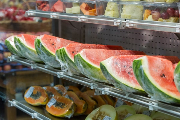 Watermelon, papaya, melon, pineapple grape, fruit on the market shelf in plastic containers or wrapped in plastic film