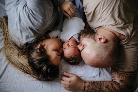 A man and woman with a baby laying down