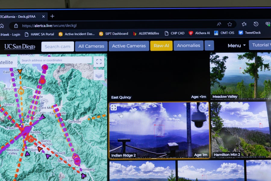 Monitor at PG&E Hazard Awareness Warning Center that displays a map and several live video feeds from forests