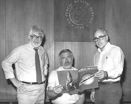 Three men hold a magazine with a cover that reads "smallpox is dead!"