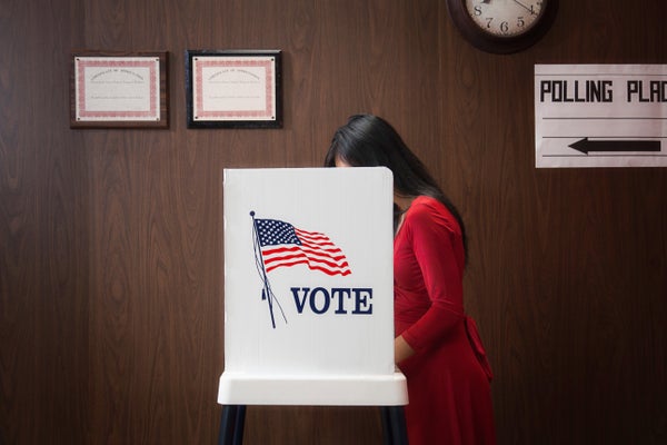 Voter, Asian adult woman, in polling place, filling out ballot