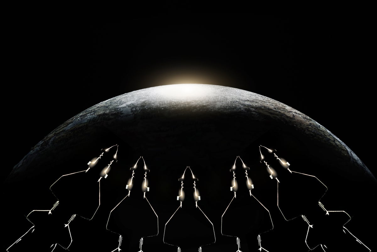 Photo illustration with missiles visible at the bottom of frame in silhouette pointed towards the contour of Earth above