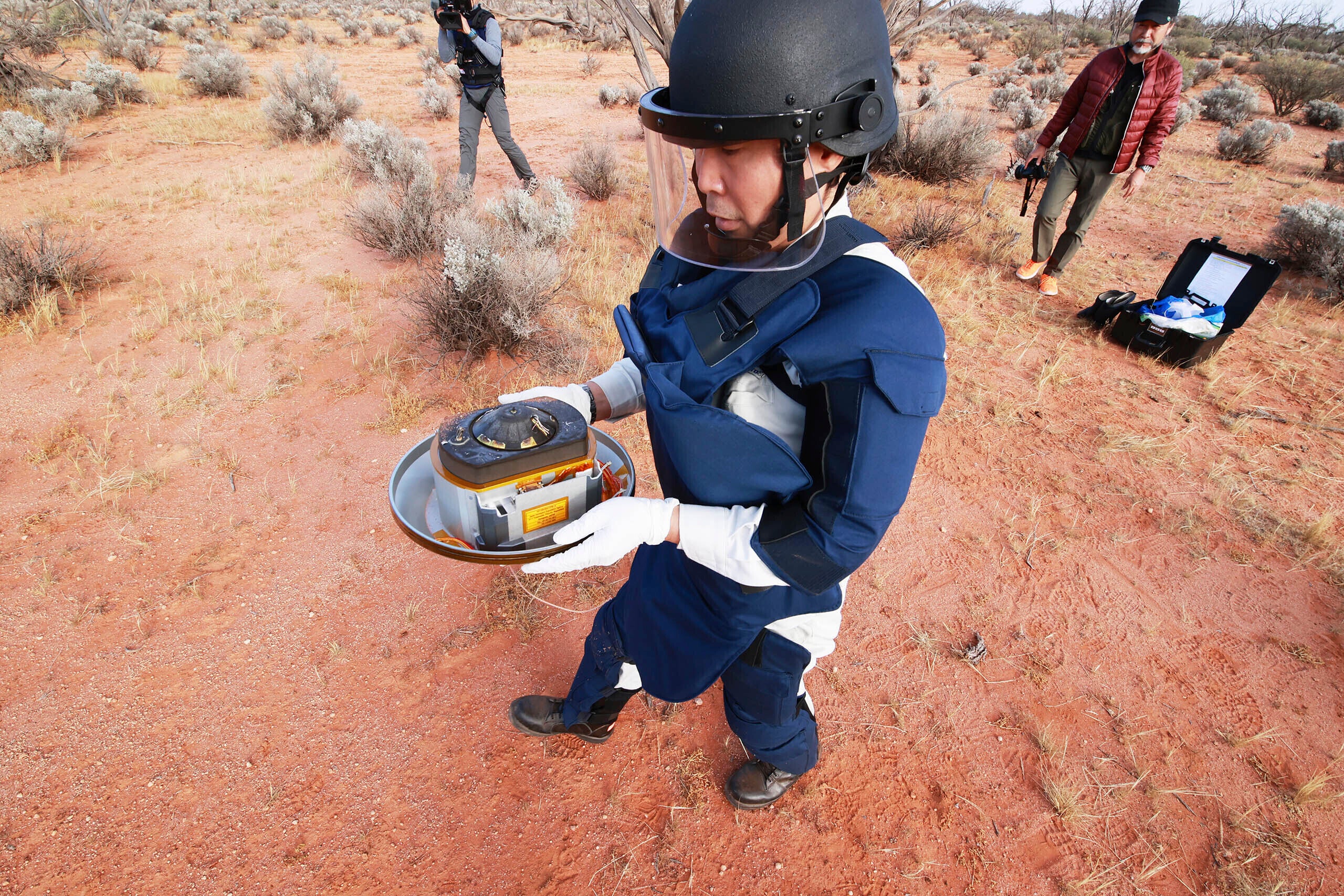 Member of the Hayabusa2 team holds the mission’s sample-return capsule