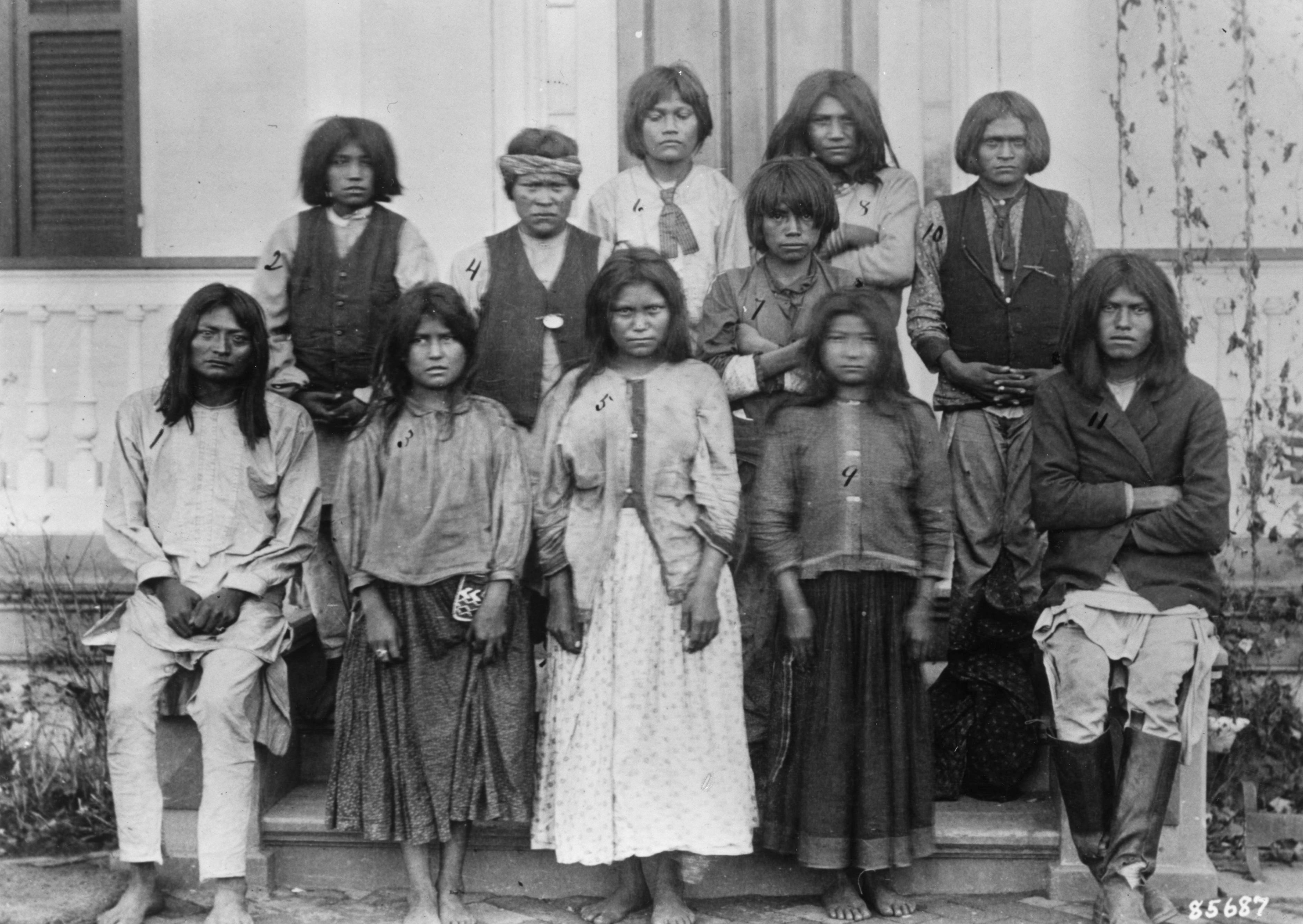 Chiricahua Apache children photographed in front of a building.
