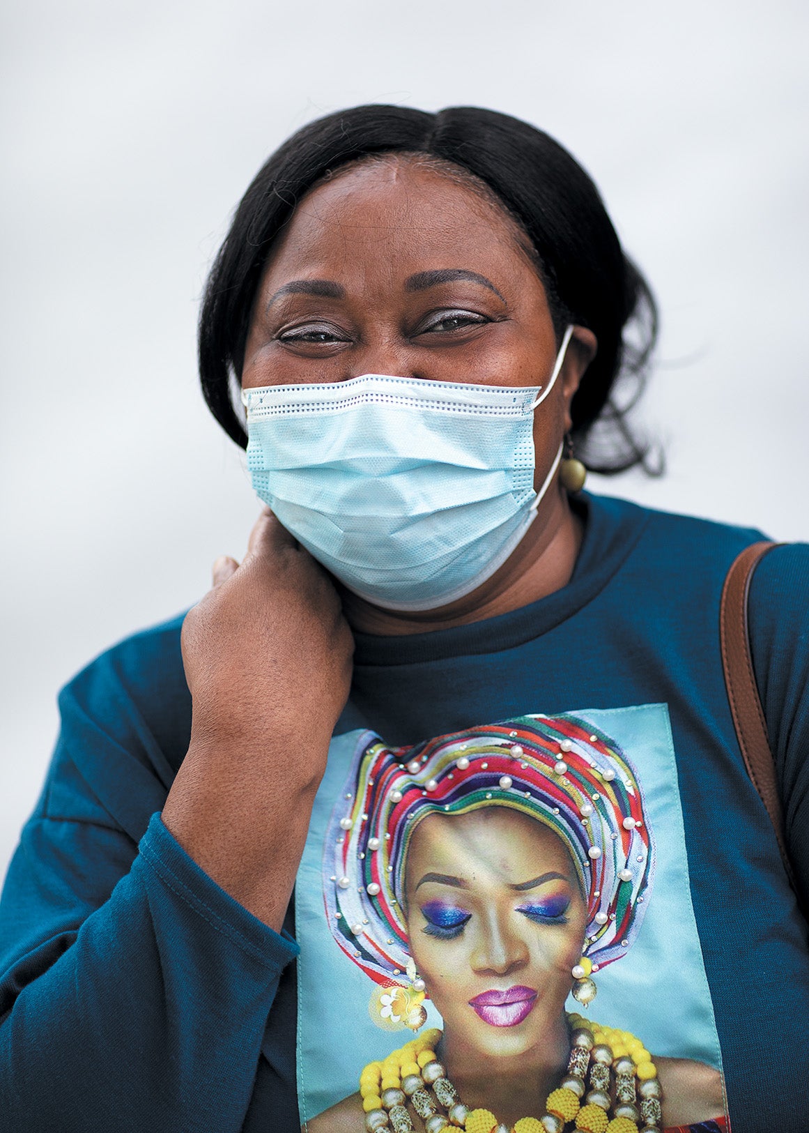 Youlanda Lee-Clendenen souriant tout en portant un masque facial debout sur fond blanc.