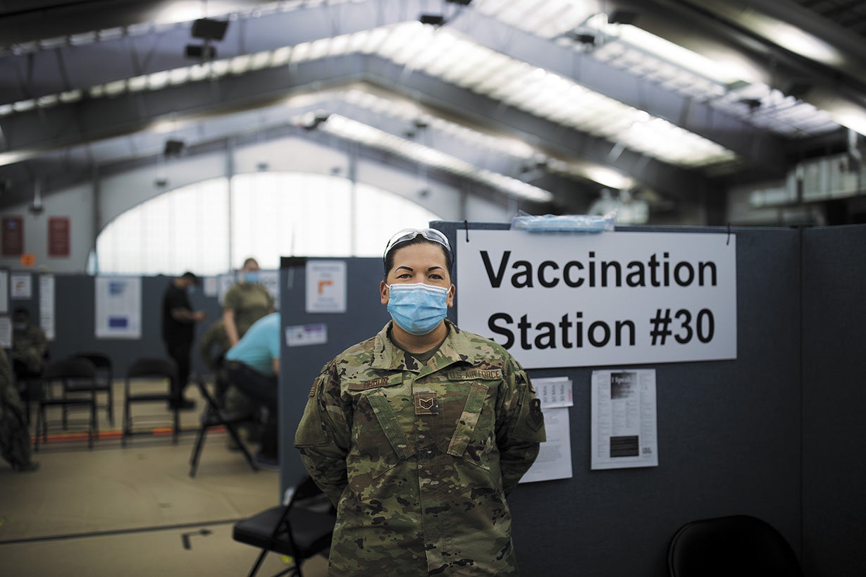Mary Breanna Hudon, die ihre Militäruniform und Gesichtsmaske trägt, steht in der Impfstelle. 