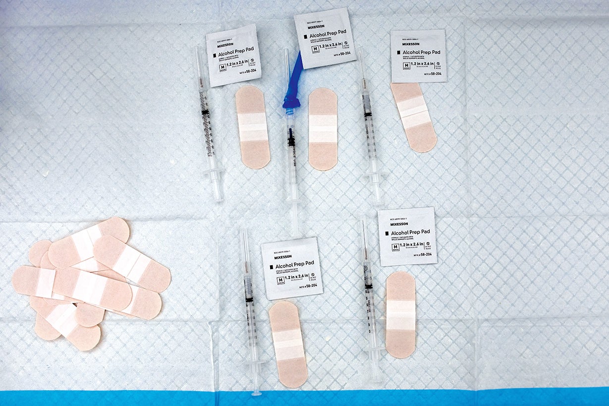 Medical tray with vaccines, syringes and bandaids. 