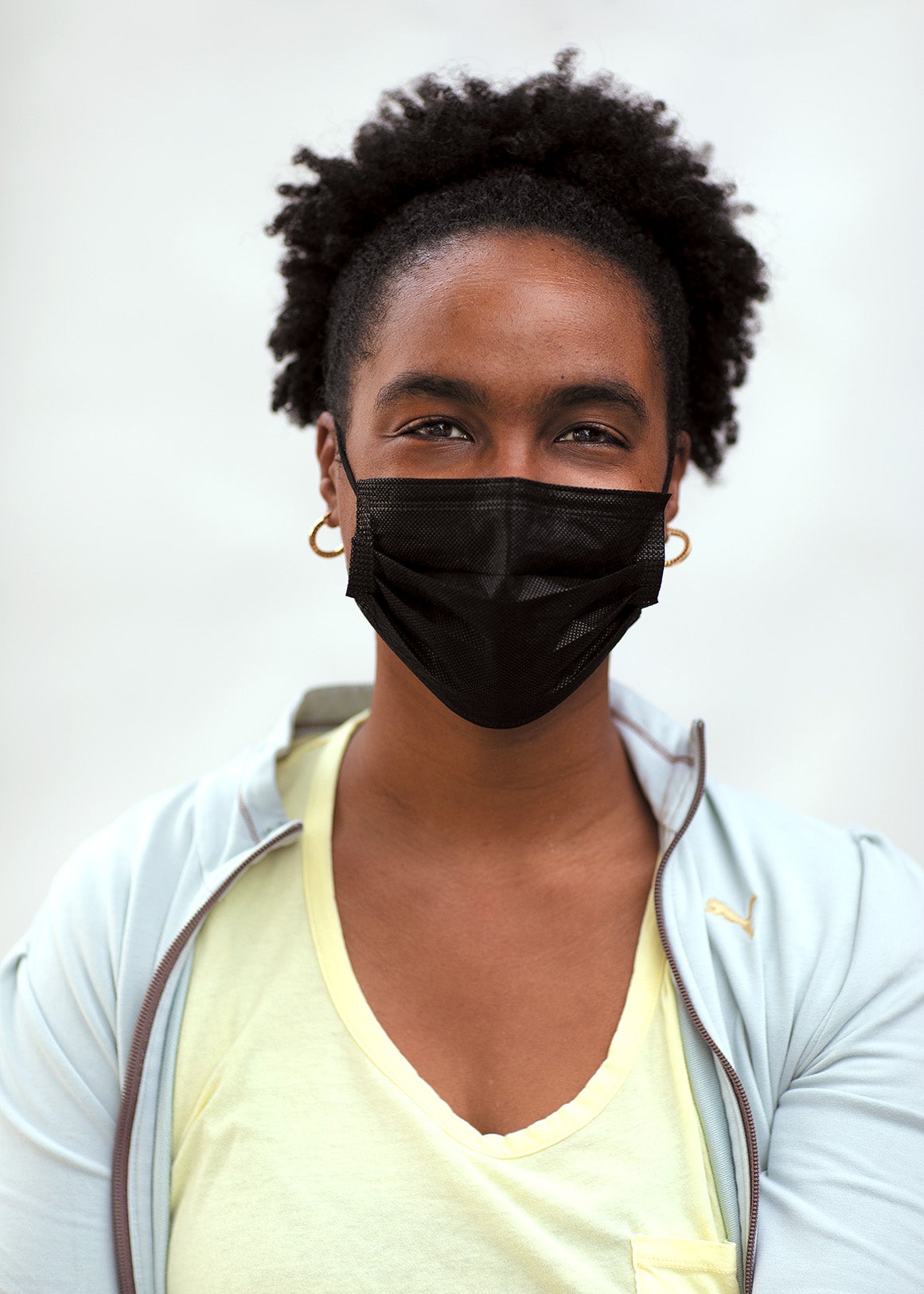 HODAN BULHAN wearing a face mask standing against white background.