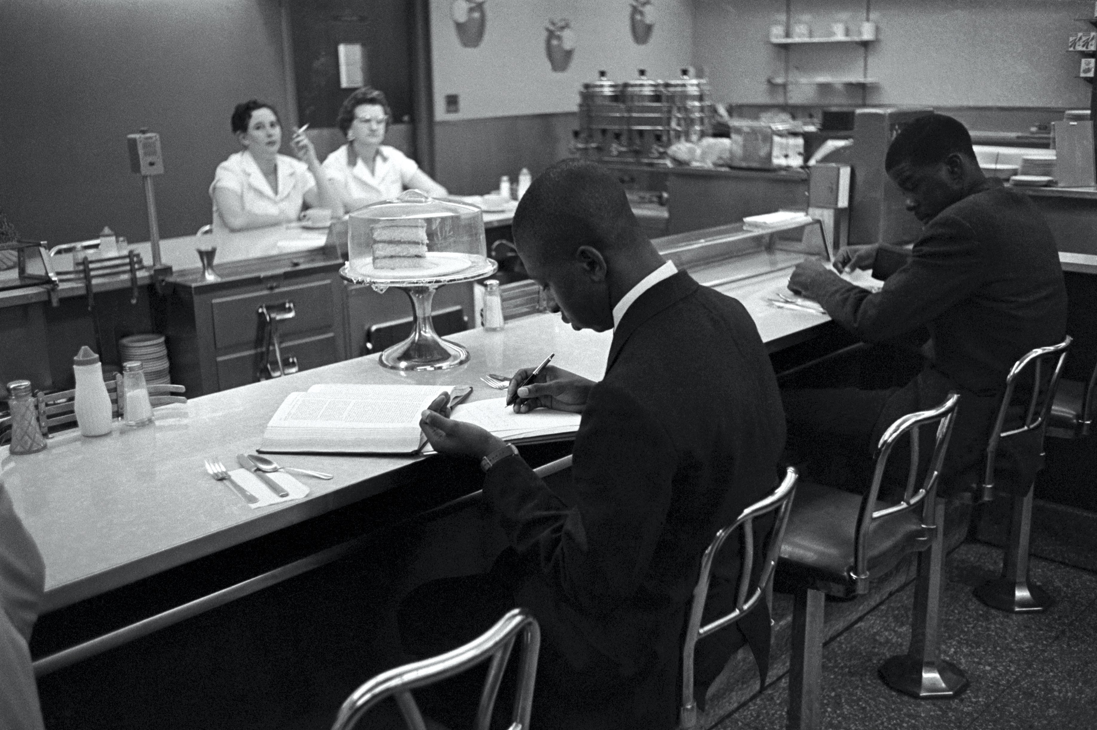 BLACK STUDENTS sit at a lunch counter reserved for white customers in Raleigh, N.C