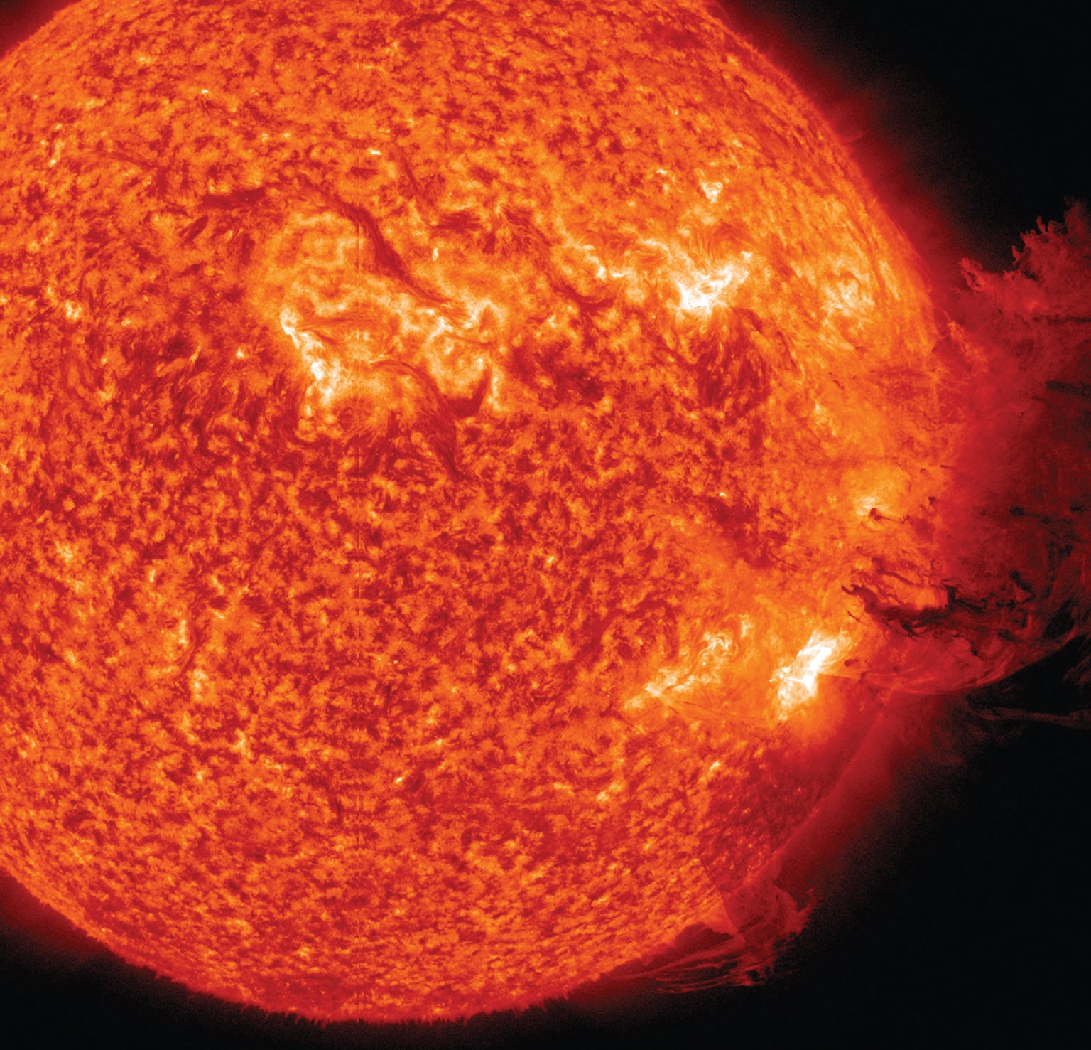 Solar flares and sheets of glowing plasma rise from a region of intense activity on the sun.