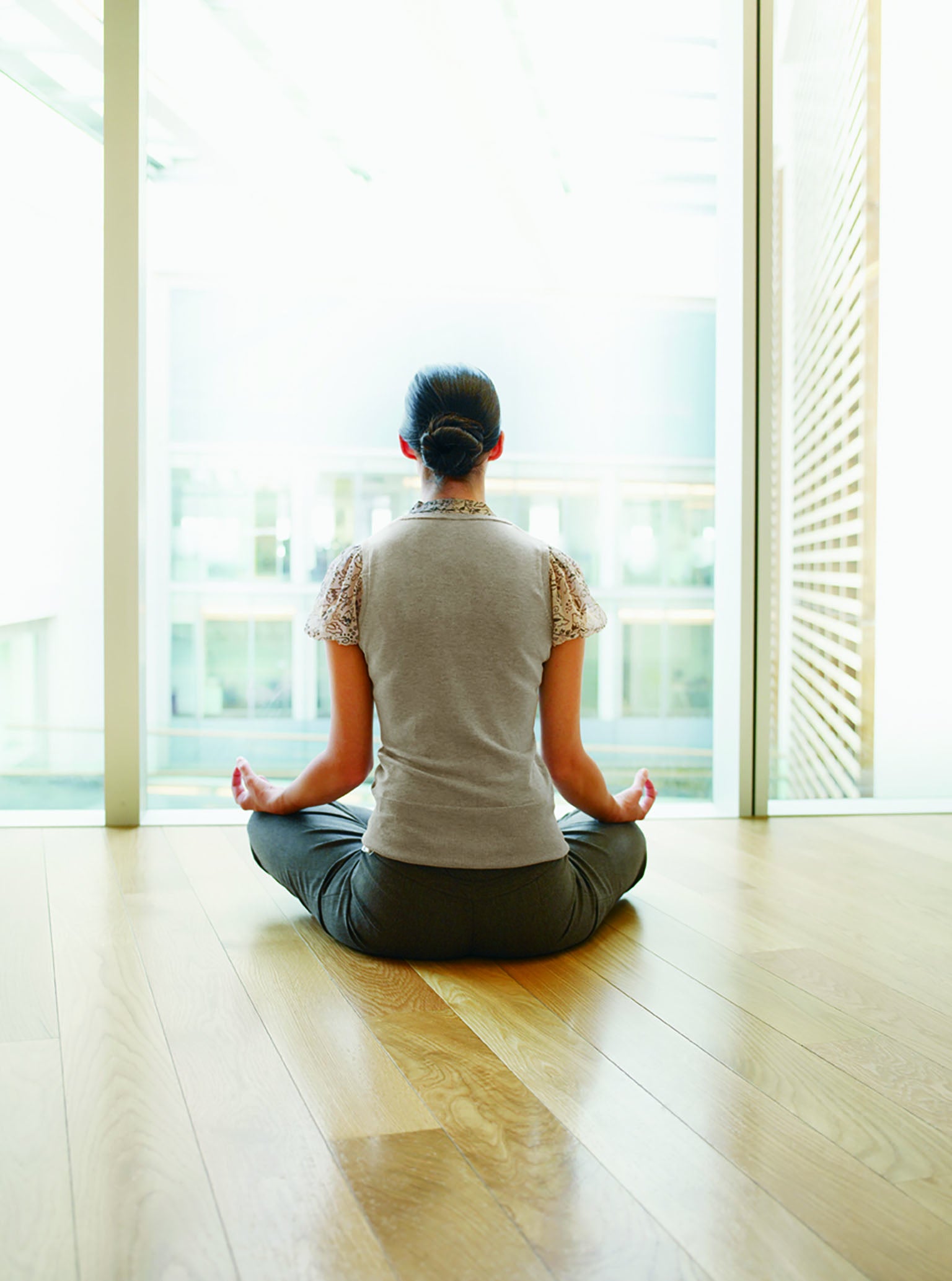 Woman meditating by a window.