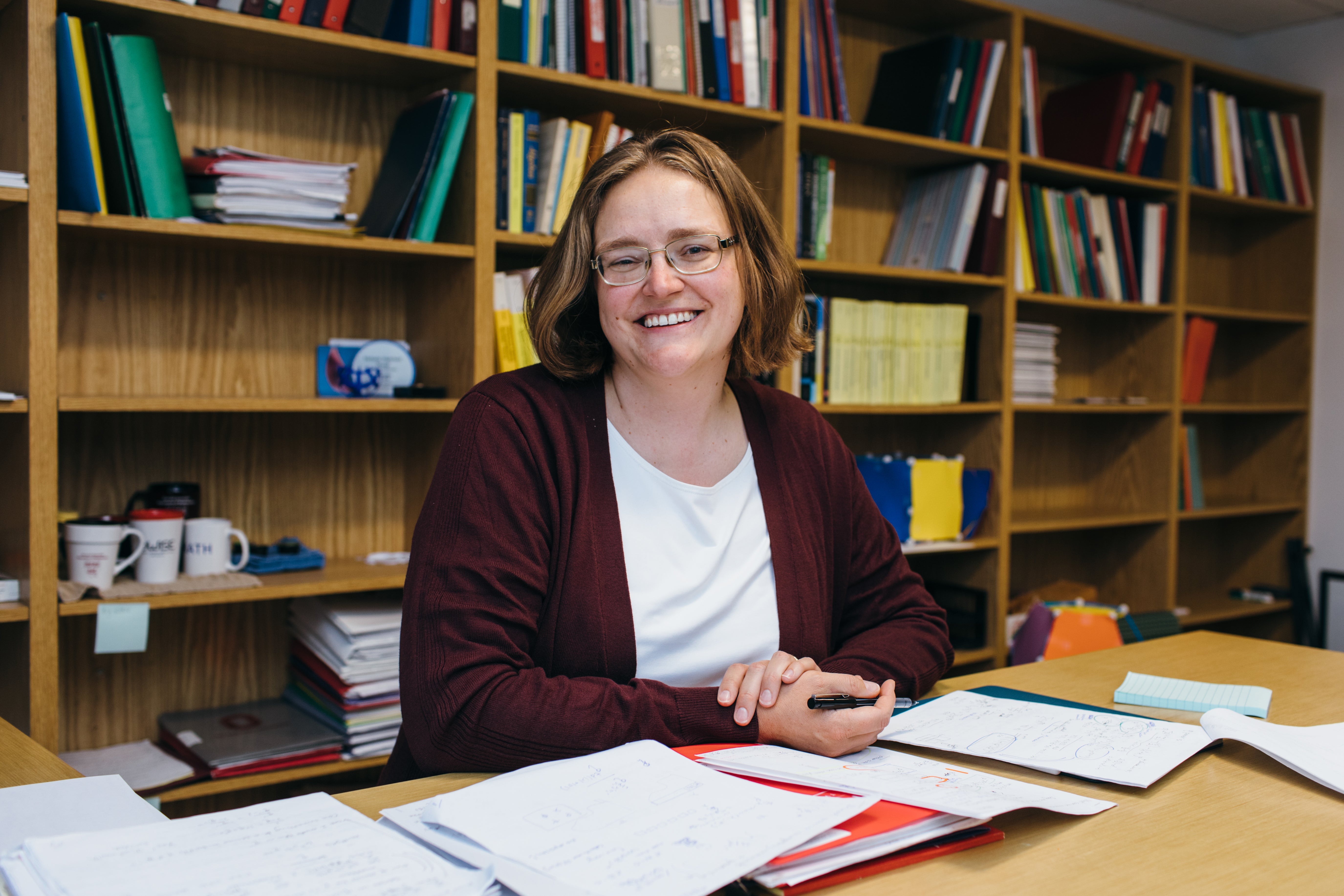 Melanie Matchett Wood sitting at a desk smiling