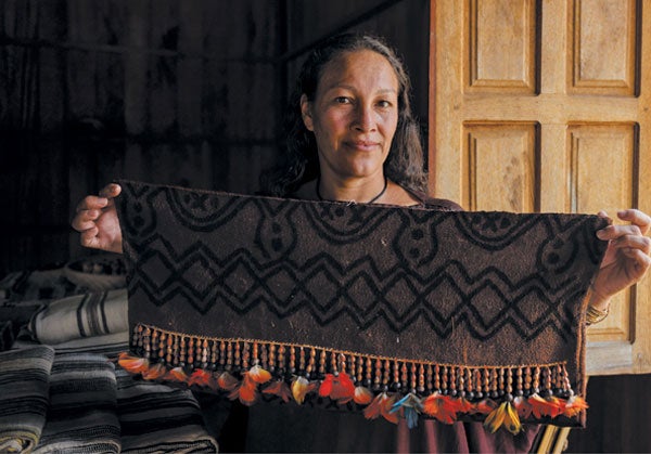 Woman displays a sling for carrying a baby.