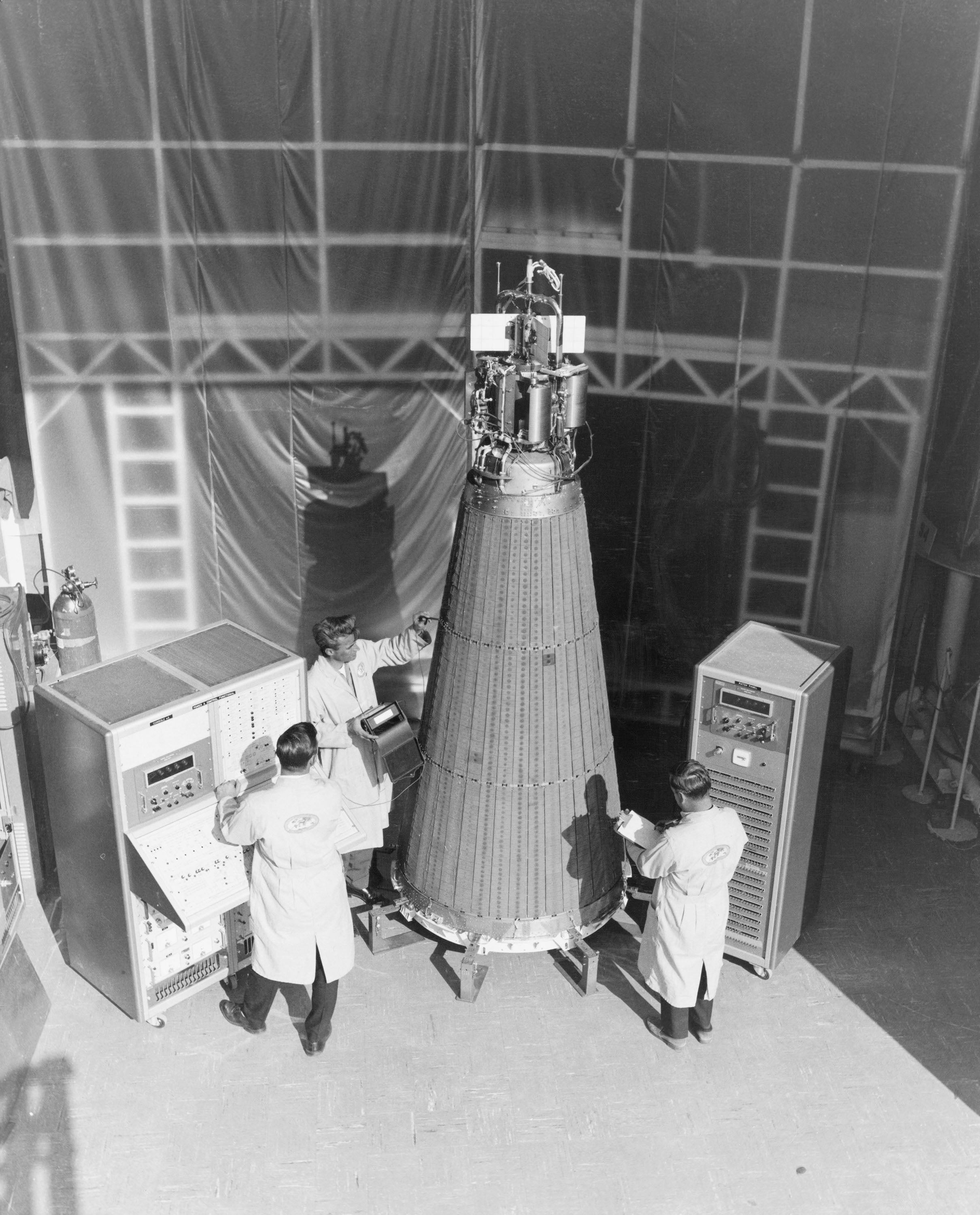 Technicians work on a test unit (center) in preparation for the April 1965 launch of SNAP-10A.