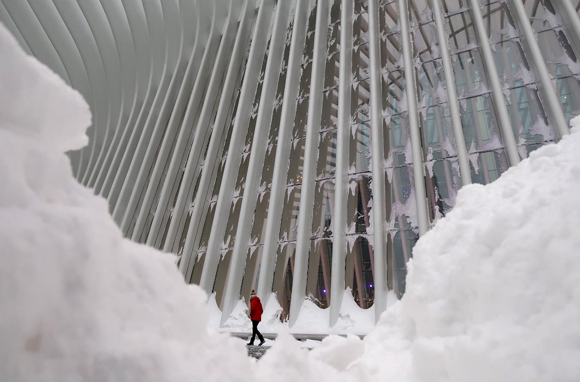 A man walks outside the Oculus transit hub in New York City during a winter “bomb cyclone” storm.