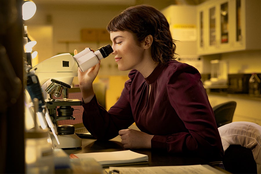 Woman looking through a microscope