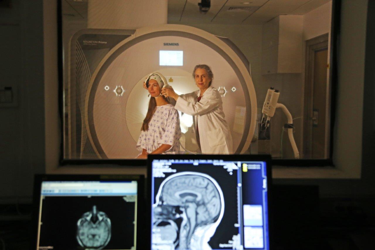 A neuroscientist readies a participant for a brain scan.