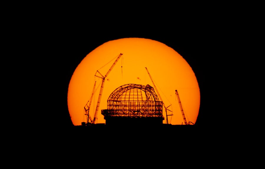 Photograph of the sunrise over Cerro Armazones, the under construction ELT seen in silhouette in front of the sun, shot on 29 August from the top of Cerro Paranal, around 23 kilometres away