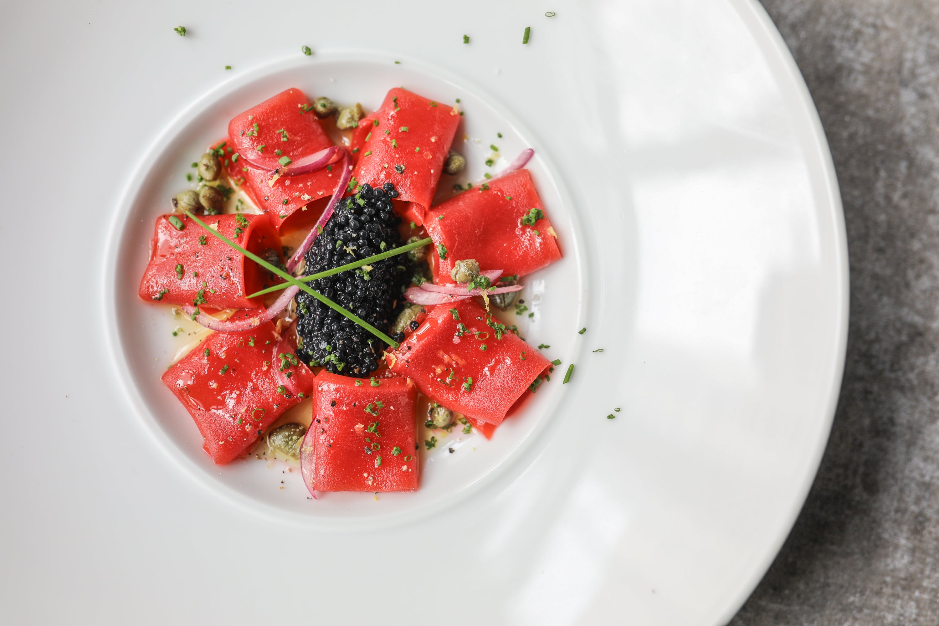 New York'ta Coletta'da kırmızı soğan turşusu, kapari, karabiber ve karadeniz yosunu havyarı ile servis edilen “ton balığı” crudo.  Ton balığı ürünü Current Foods'a aittir. 