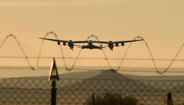 Virgin Galactic SpaceShipTwo despega en el desierto de Mojave, California, visto detrás de una valla de alambre de púas