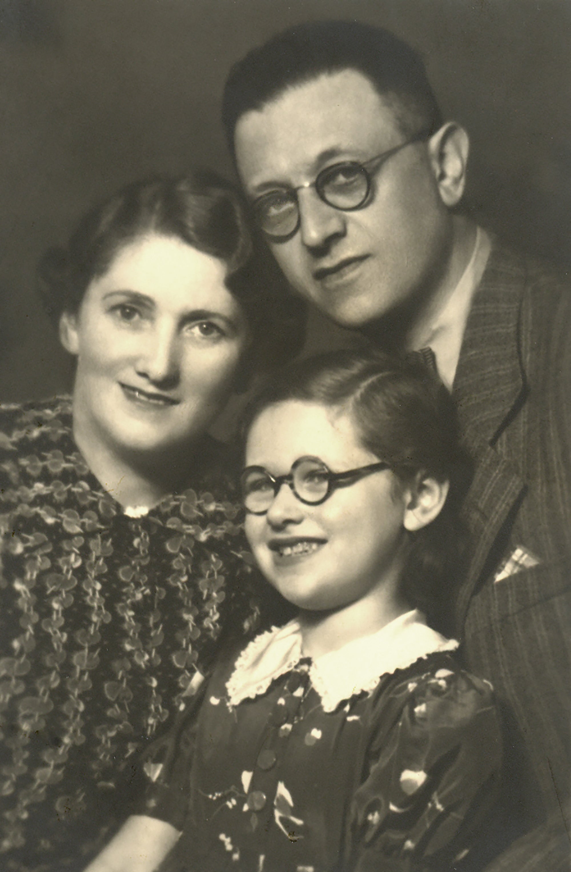 Black and white portrait of a child with parents.