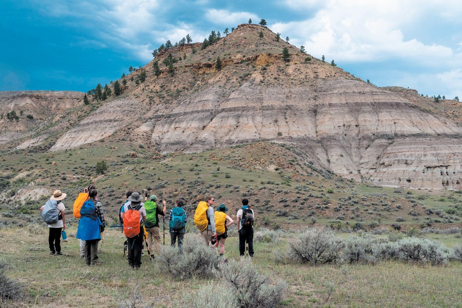 A group of people in hiking gear in a desert mountain landscape.