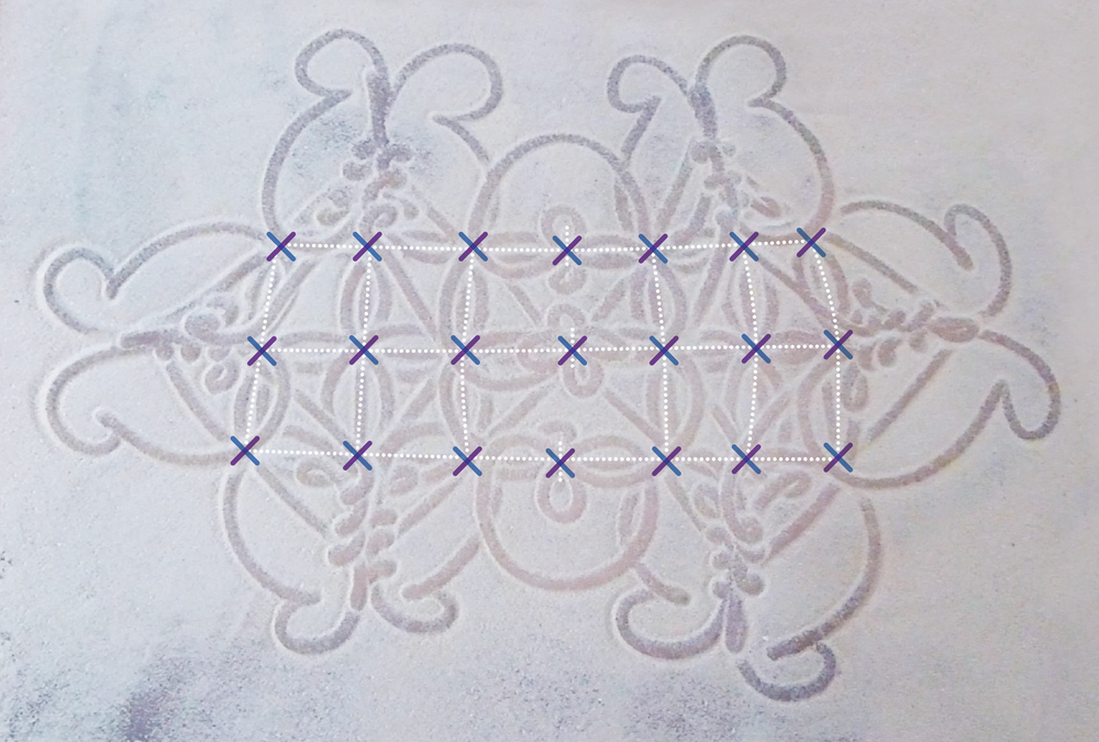 At the crossing points of a sand drawing design, each diagonal line is shown in a different color