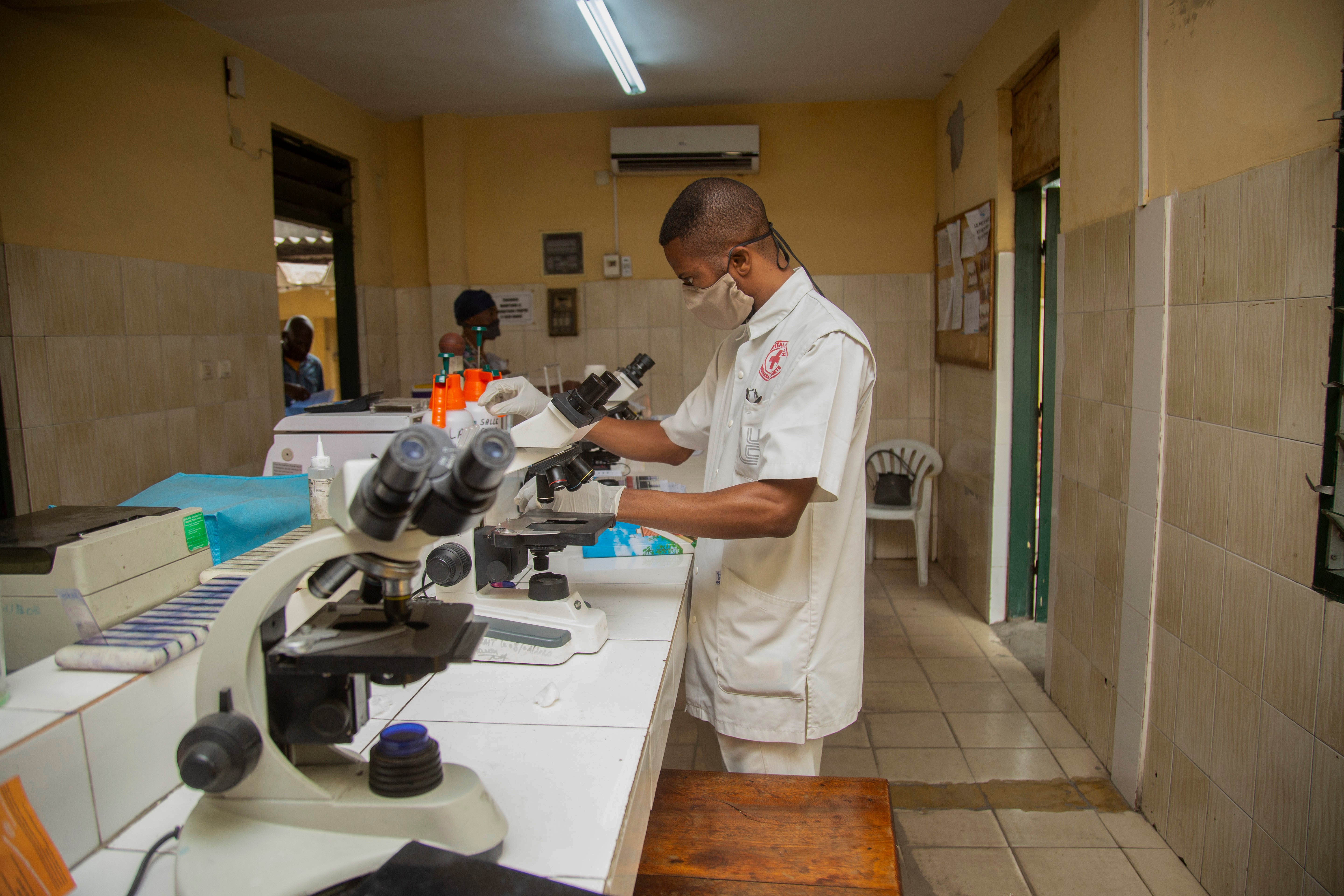 A health-care worker tests samples from people with COVID-19 as part of the ANTICOV trial. 