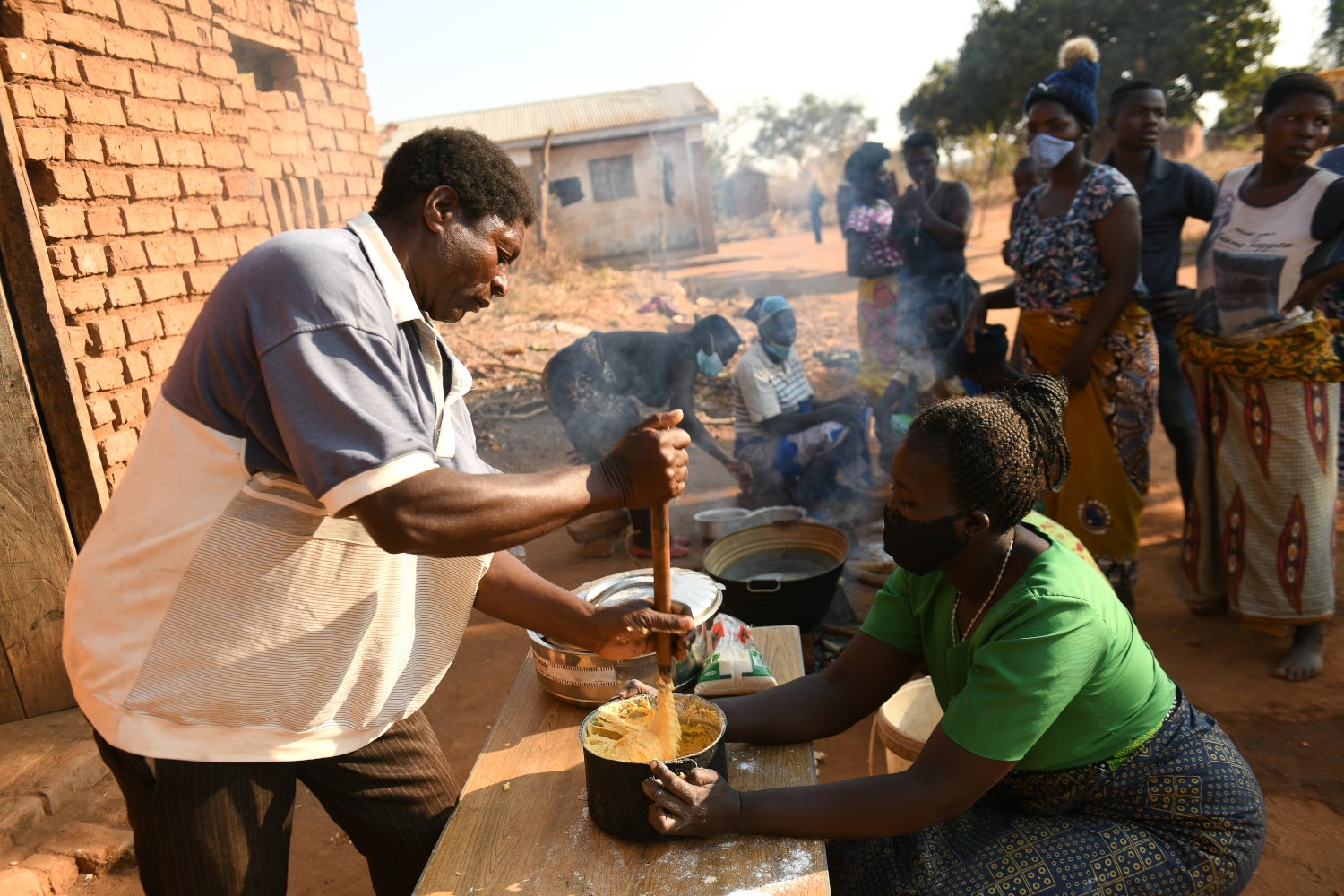 Winston Zgambo helps Anita Chitaya prepare bean-flour doughnuts.