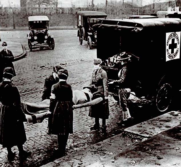 Red cross nurses in St. Louis load a flu patient into an ambulance in 1918