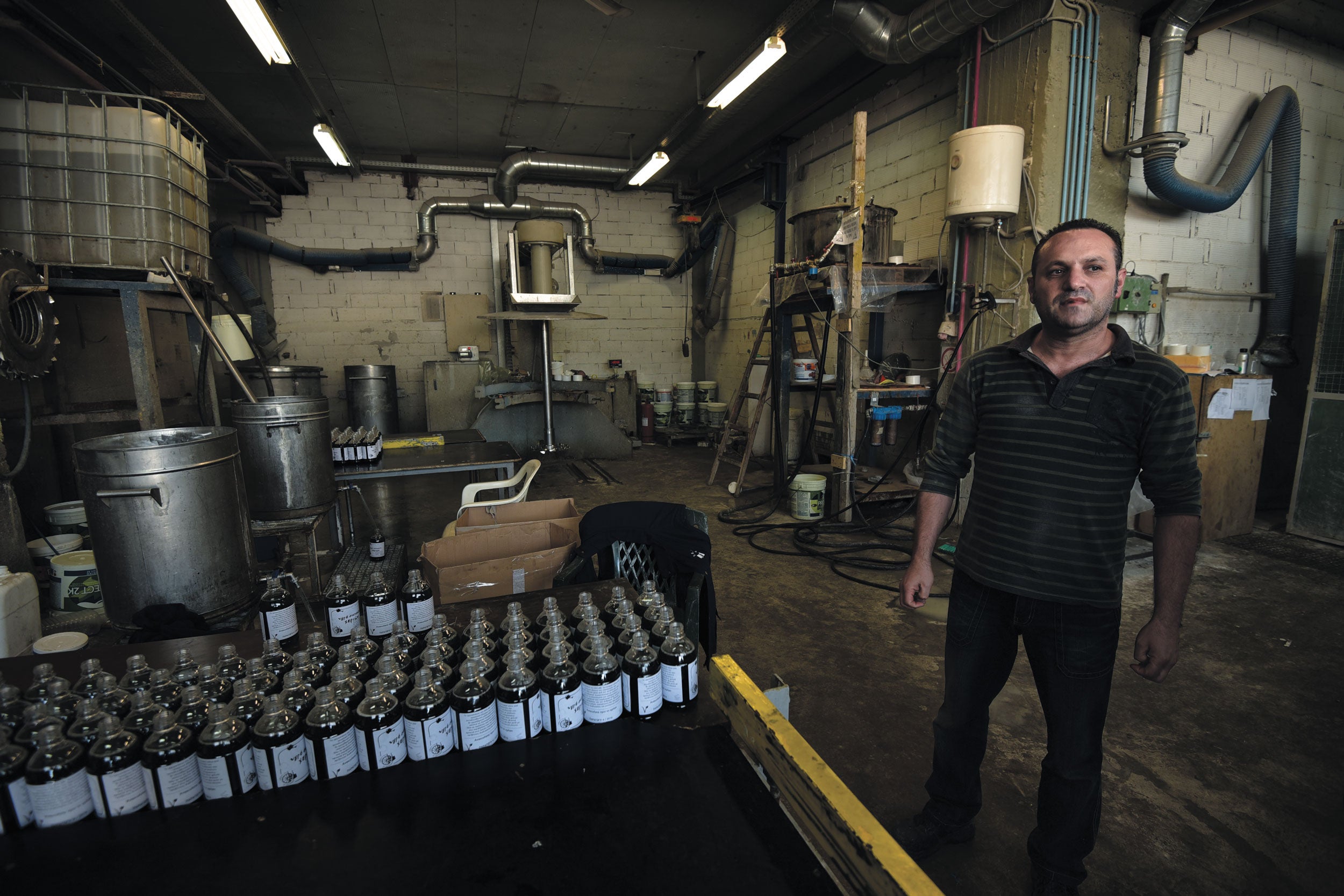 Dimitris Koumatsioulis standing inside a an eco-friendly detergent factory in Thessaloniki, Greece.