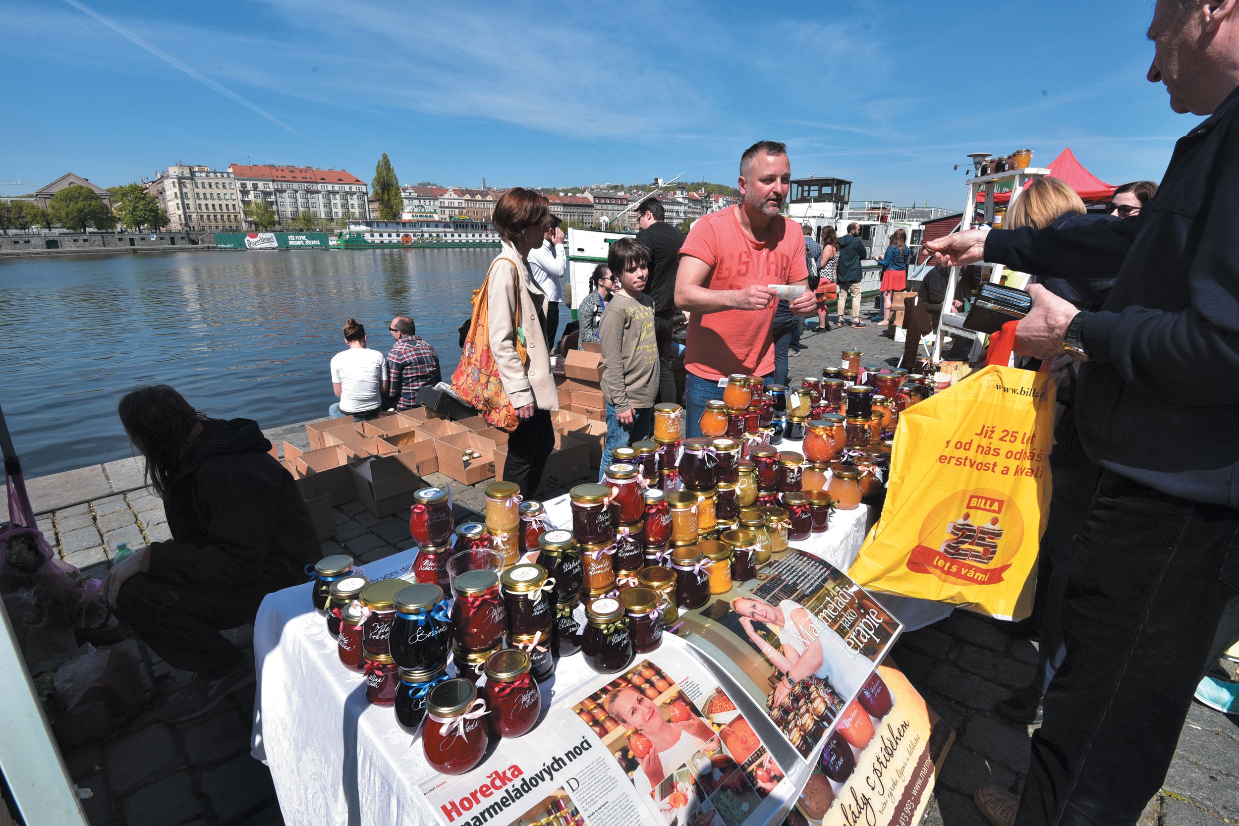 People buying and selling at a farmers' market in Prague, Czech Republic.