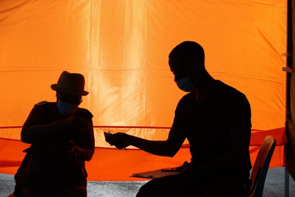 Two figures appear in silhouette inside a tent.