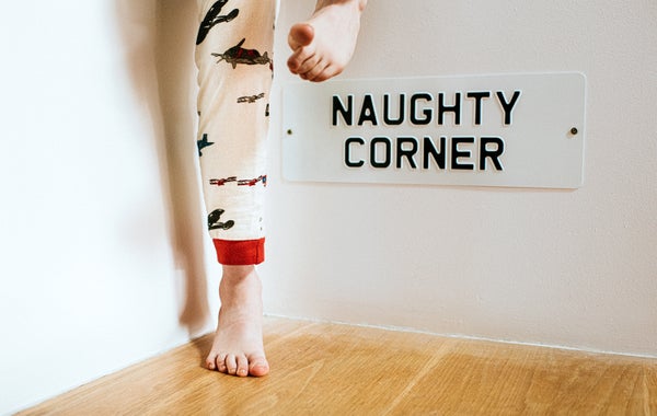 Child standing in 'naughty corner.'