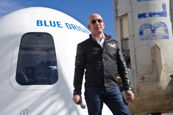Jeff Bezos standing in front of Blue Origin spacecraft.