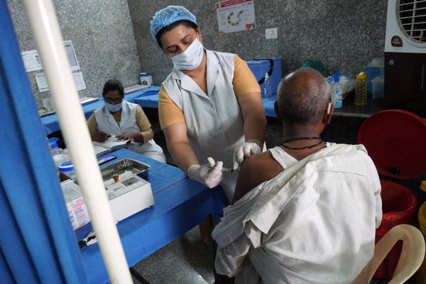 A seated patient recieves a vaccine shot.