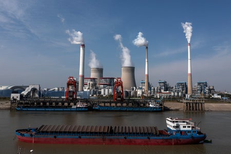 An aerial view of the ships carrying coal with smoke stacks in background