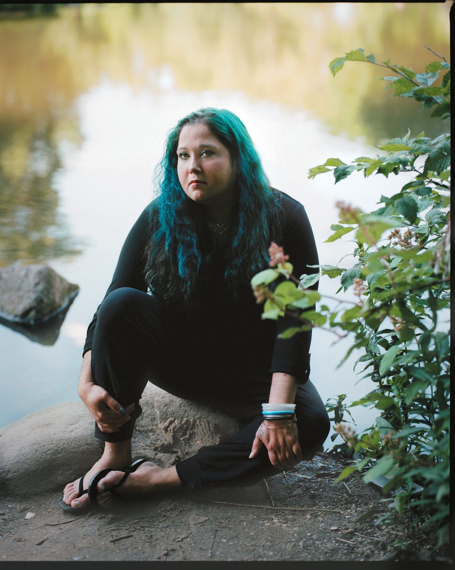 Maria Mazurkevich izgleda zamišljeno, sjedi na grani drveta pored jezerca.