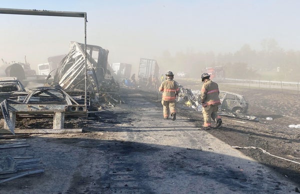 First responders walk among wreckage of highway accident