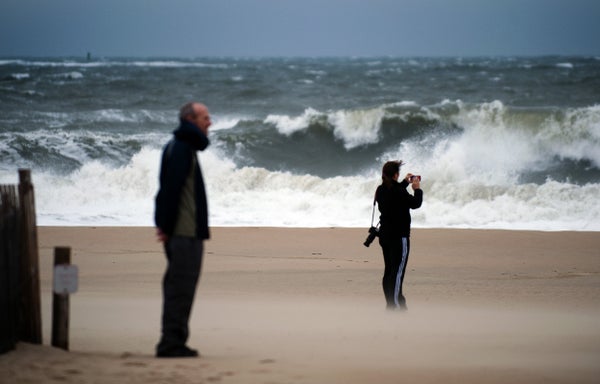A man and woman view the storm surge from Hurricane Sandy.